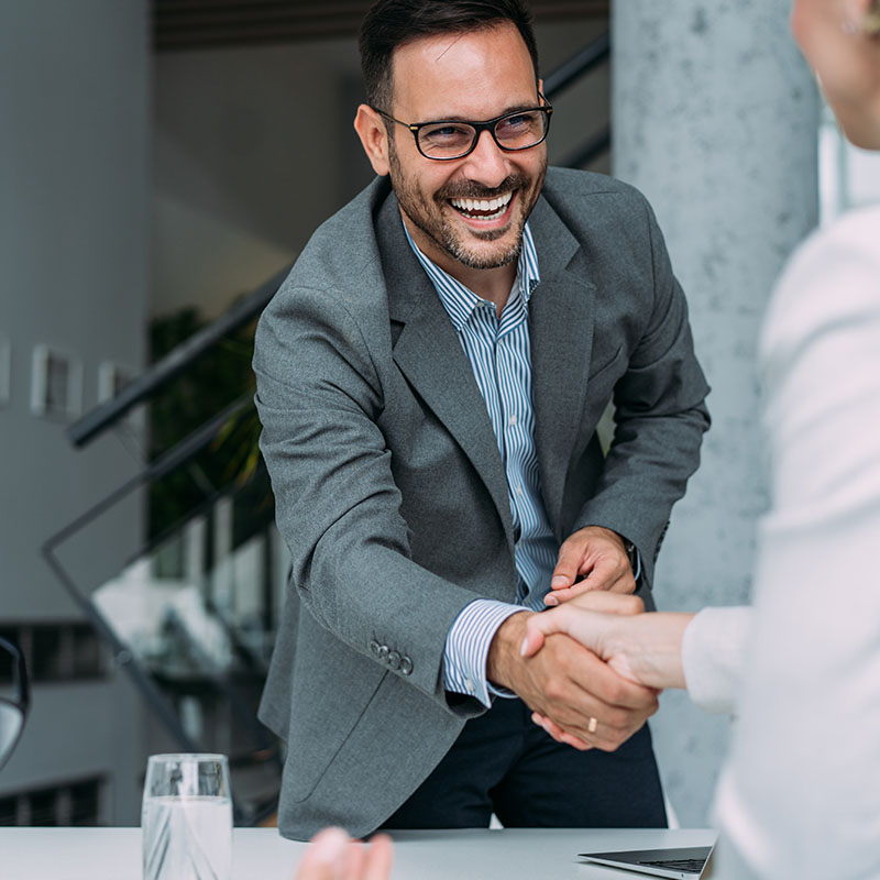 Business people handshaking across the table during a meeting in modern office